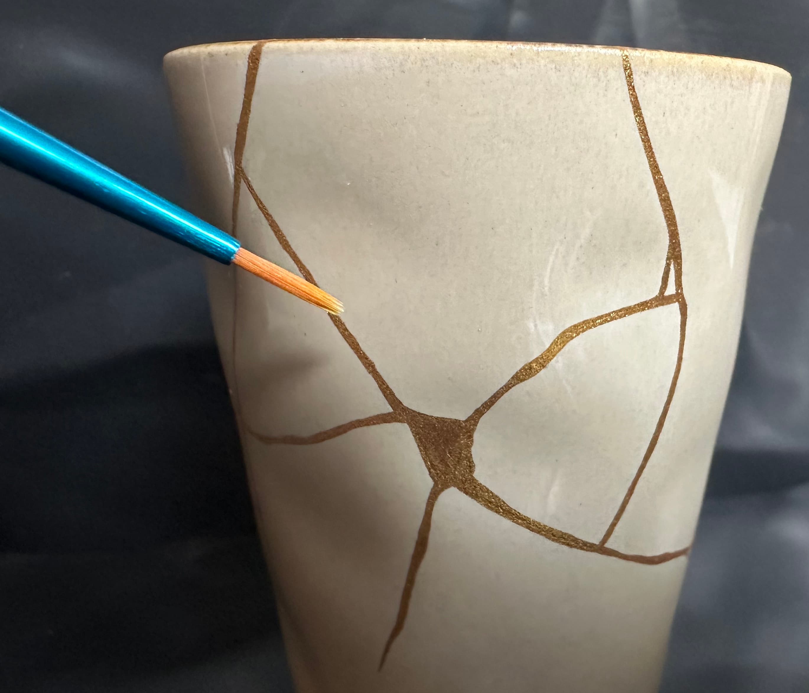 Vase kintsugi avec un pinceau